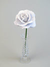 Leafless white lace printed paper rose standing in a slender glass vase