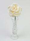 Leafless white paper rose standing in a slender glass vase